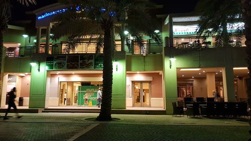 Illuminated street amidst buildings at night