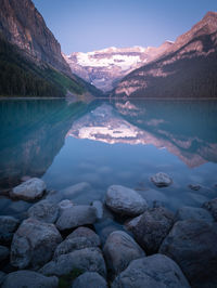 Beautiful alpine lake reflecting its surroundings, sunrise at lake louise, banff, canada