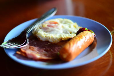 Close-up of breakfast served in plate on wooden table