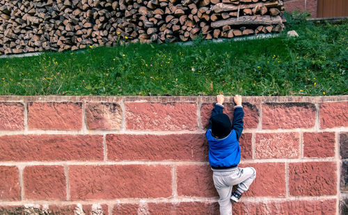Man standing on brick wall
