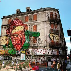 Low angle view of graffiti on building against sky