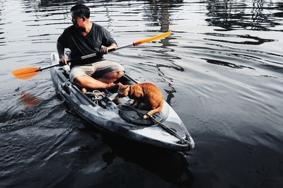 Man with dog on boat in lake