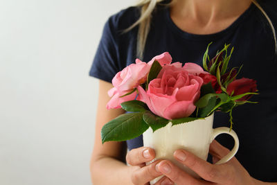 Midsection of woman holding pink roses