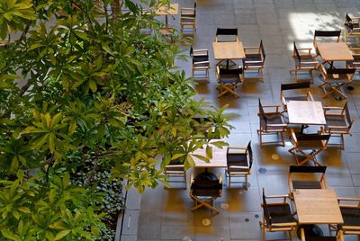 Empty chairs and table arranged in sidewalk cafe