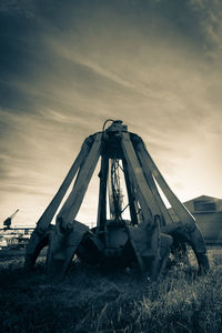 Abandoned boat on field against sky