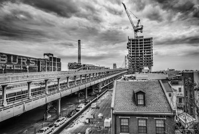 Buildings in city against cloudy sky