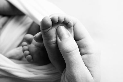 Close-up of hand holding baby's leg