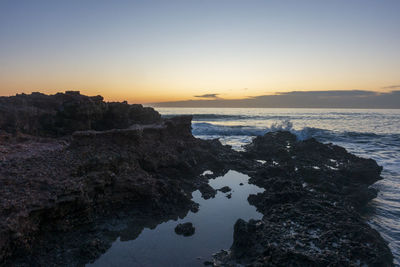 Scenic view of sea against clear sky during sunset