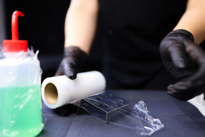 Close-up of hand holding glass bottle on table