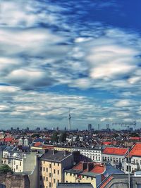 Buildings in city against cloudy sky