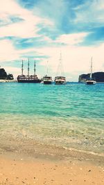 Sailboats in sea against sky