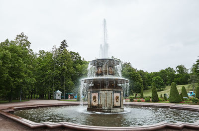 Fountain in city against sky