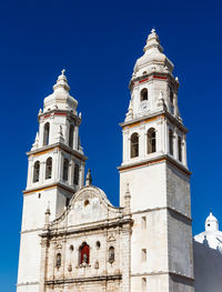 Low angle view of bell tower against blue sky