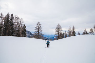 Rear view of people skiing on snow