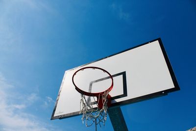 Low angle view of basketball hoop against blue sky