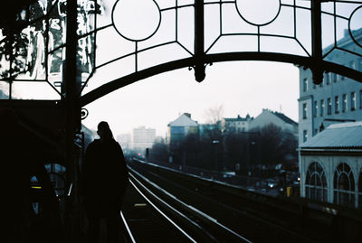Silhouette man in city against sky