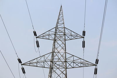 Low angle view of electricity pylon against clear sky