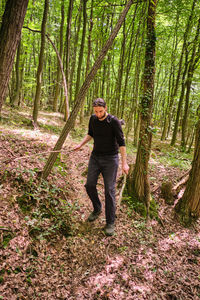 Full length of woman standing in forest