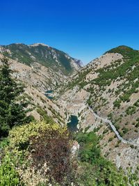 Scenic view of mountains against clear blue sky