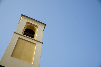 Low angle view of bell tower against blue sky