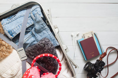 High angle view of luggage with camera and passport on table