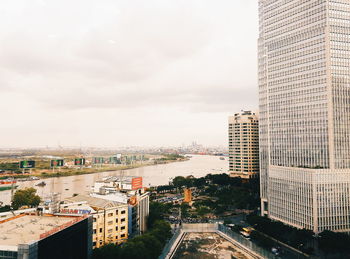 Buildings in city against cloudy sky