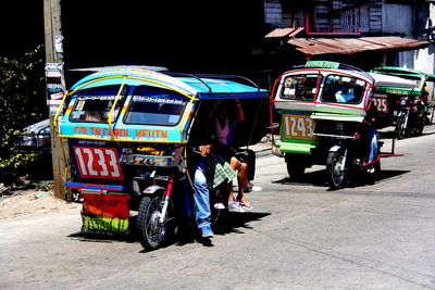 People in pedicab on street