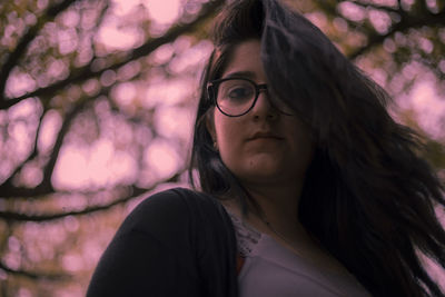 Portrait of smiling woman standing against trees