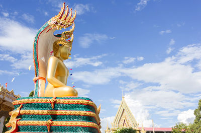 Low angle view of statue against temple against sky