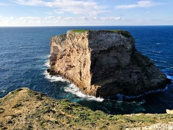 Rock formations by sea against sky