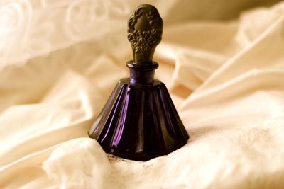 Close-up of perfume bottle on dress