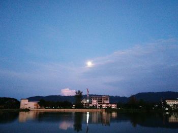 Buildings by lake against sky in city