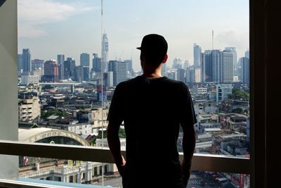 Rear view of man looking at city buildings