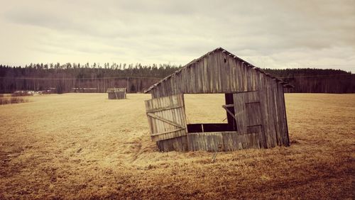 View of field against cloudy sky