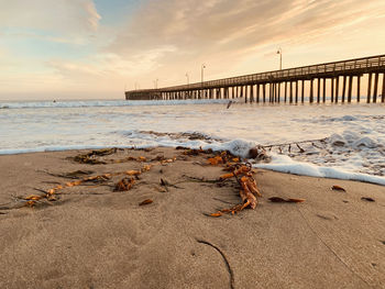 Pier over sea against sky during sunset