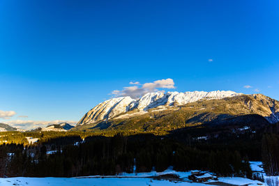 Scenic view of snowcapped mountains against blue sky