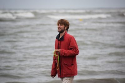 Young man standing on shore at beach