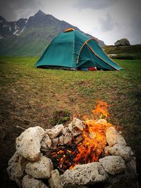 Tent on field by mountain against sky