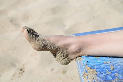 Close-up of female foot on the beach
