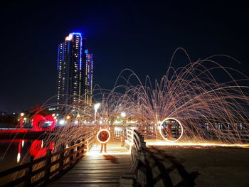 Illuminated city buildings against sky at night