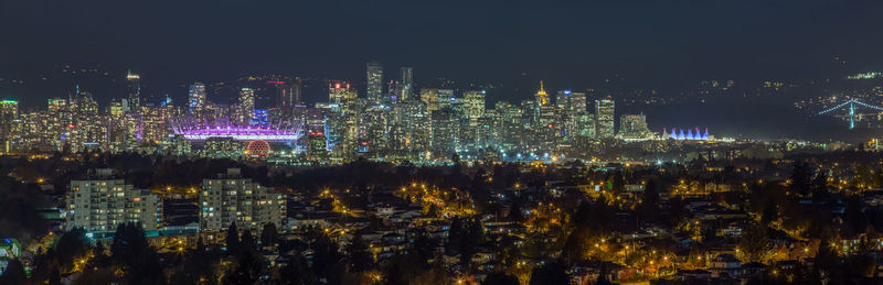 Illuminated buildings against sky at night