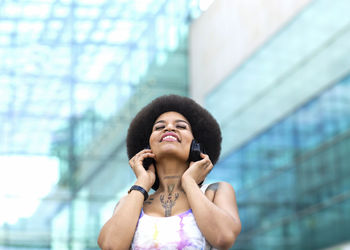 Portrait of young woman standing against wall