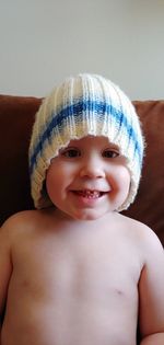 Portrait of smiling boy in knit hat at home