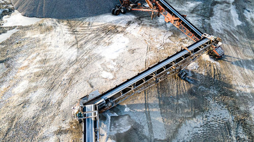 Open pit rock quarry with stone traveling on conveyors to massive gravel piles