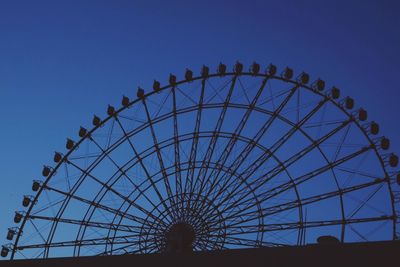 Low angle view of ferris wheel against blue sky