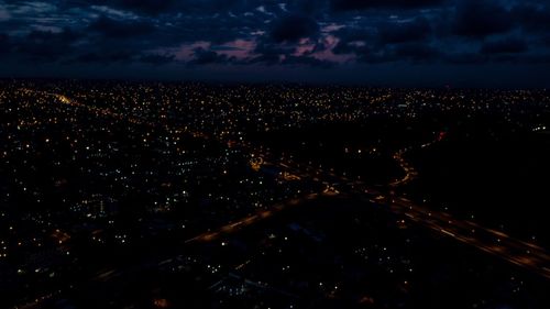 High angle view of illuminated city against sky at night