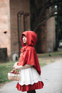 Midsection of woman standing by red basket