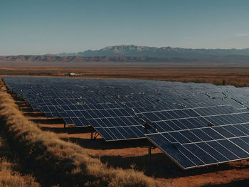 Solar panels on field against clear sky