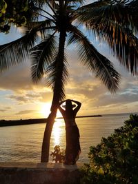 Scenic view of palm trees on beach during sunset