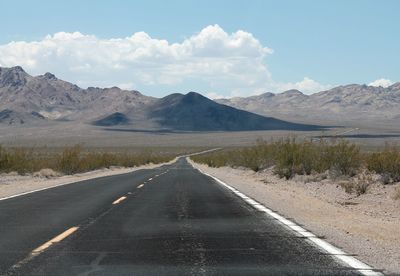 Surface level of road amidst mountains against sky